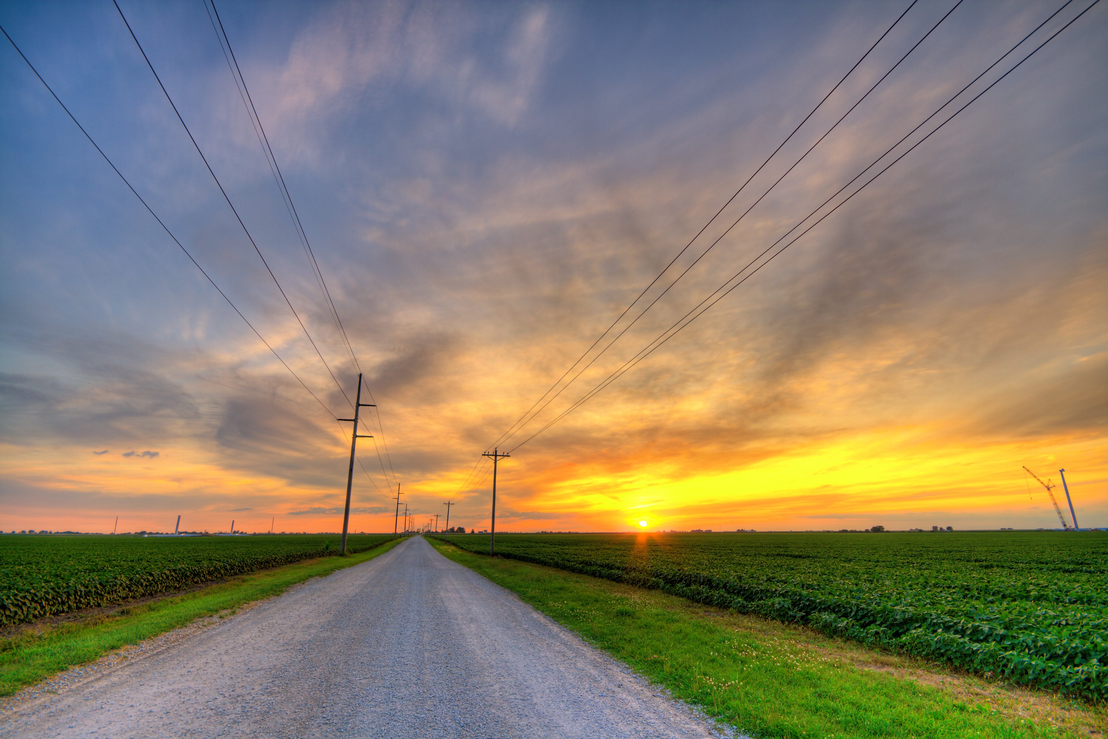 Rural Sunset with Power lines on both sides of a country road