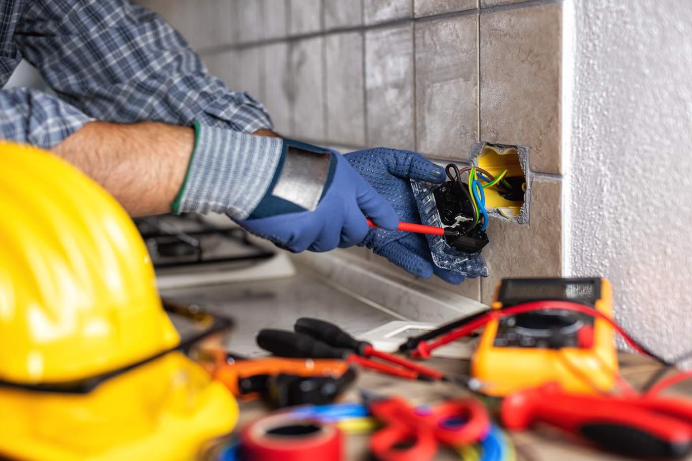 electrician wiring up a socket in kitchen