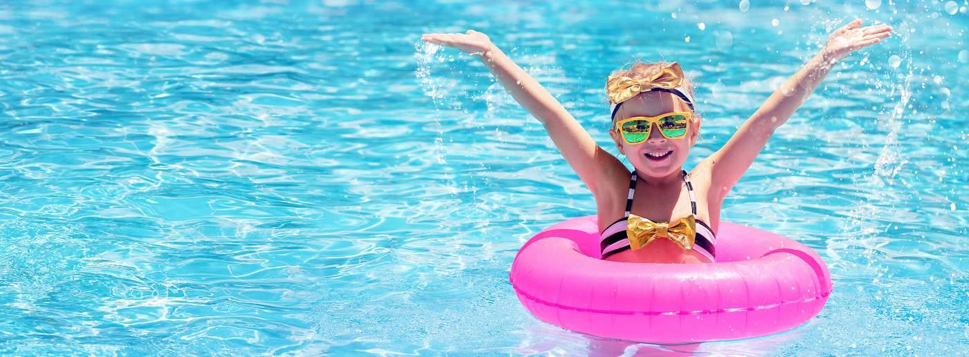 little girl in pool with sunglasses and pink tube