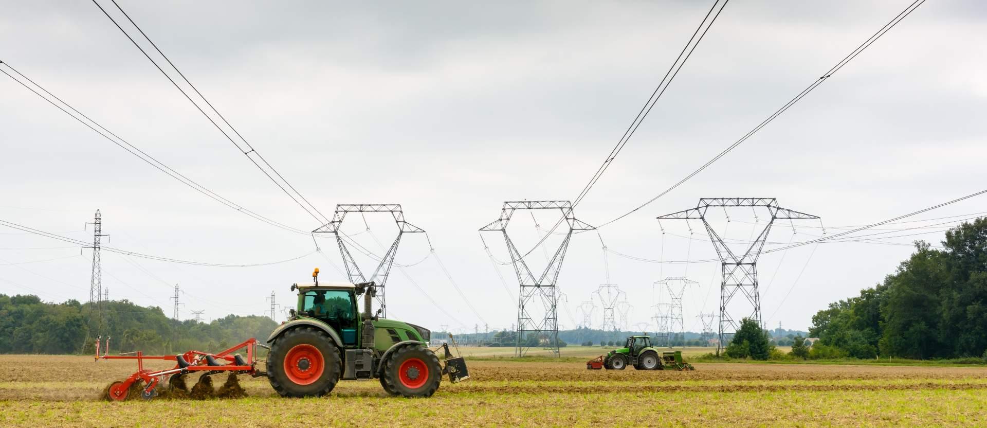 tractors plowing under high voltage lines