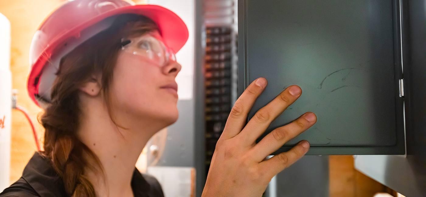 woman inspecting electrical panel of a home