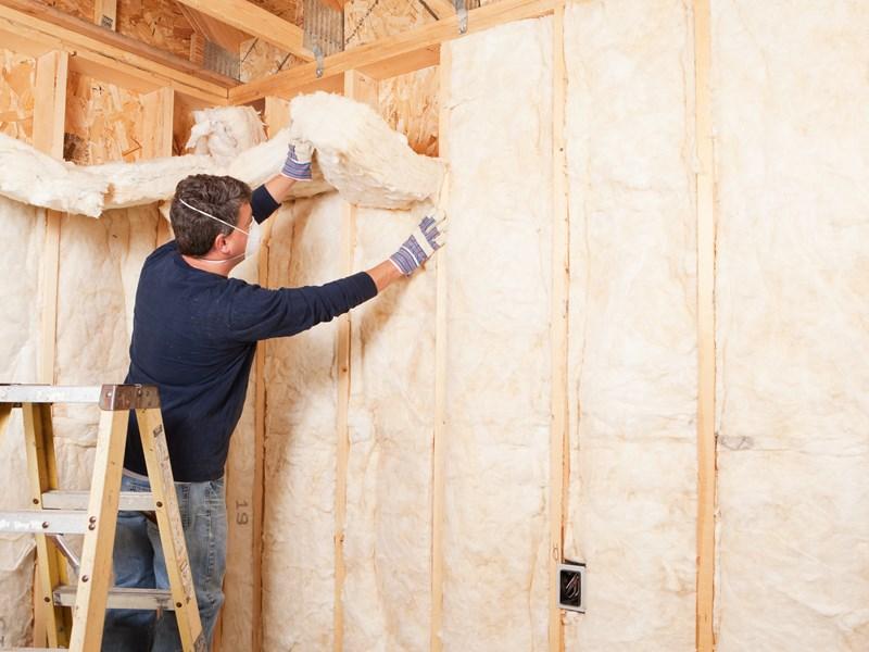 man installing wall insulation